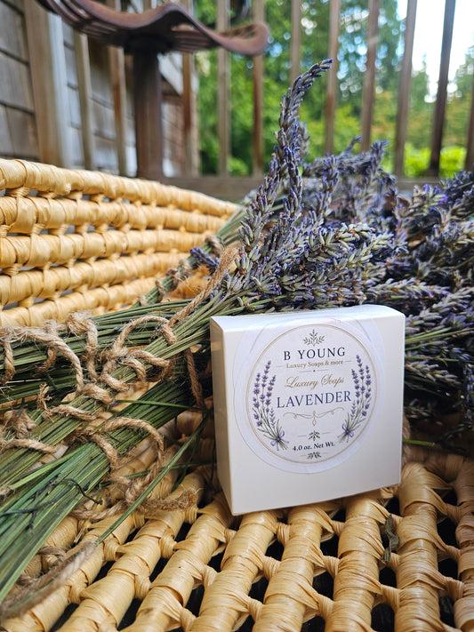 White B Young Lavender soap box beside tied lavender bundles in a woven basket.
