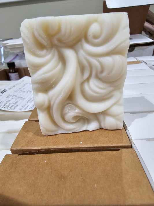 Cream-colored Swirly Whisper of Sandalwood soap bar with a sculpted swirl pattern.
